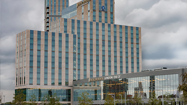 Outside view of a large, multi-storey modern hotel with blue windows.