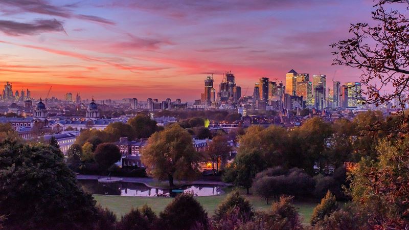 Views of a sunset over Greenwich and Canary Wharf from Greenwich Park.