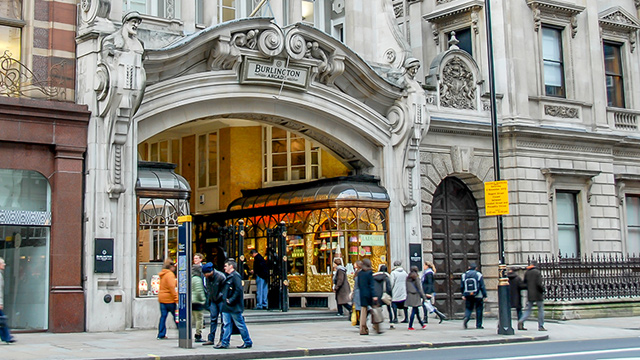 Don’t miss out on Burlington Arcade's pretty stores. Image courtesy of Shutterstock. People walking past the Burlington Arcade entrance on Piccadilly in central London.