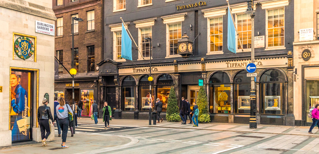 People walking around streets of Mayfair on a sunny day.