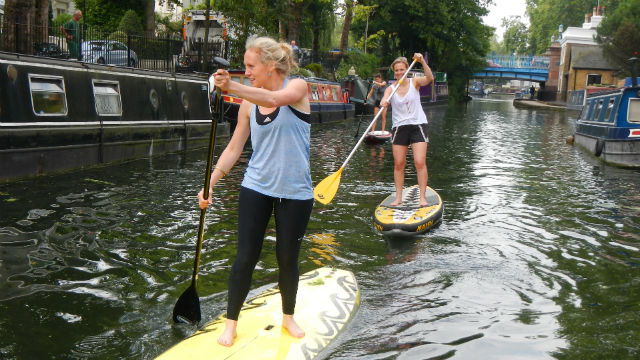 Girls paddle boarding along Paddington canal