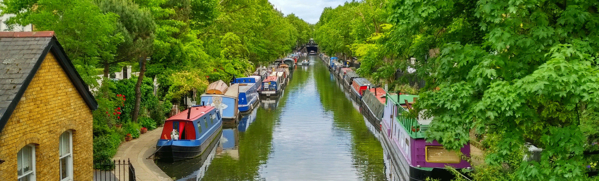 Image of boats and river surrounded by leafy trees in Little Venice