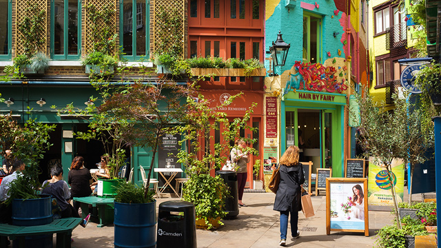 Explore Neal's Yard's colourful streets and shops. Image courtesy of Shutterstock. Colourful buildings and a woman wandering about in Neal's Yard, central London.