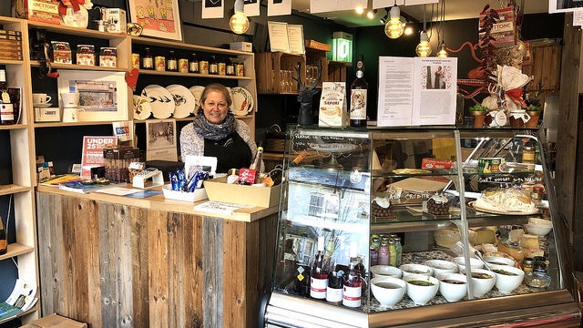 woman stands at shop counter in The Italian Delicatessen of Walthamstow 