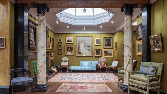 The silk room at Leighton House Museum with picture frames and paintings hung on the walls.