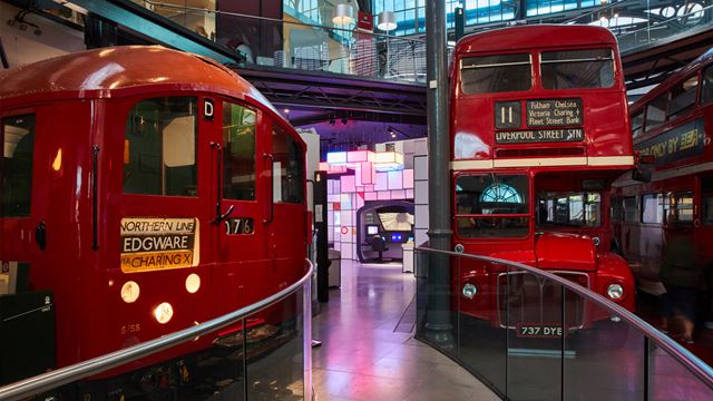 Old London transport in a museum scene, bright red London bus and an old red train carriage