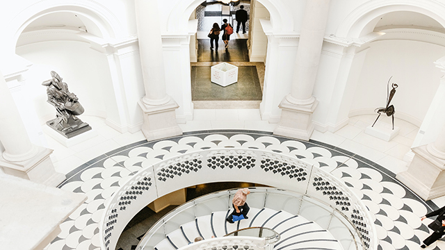 Tate Britain, Photo by Miguel Sousa on Unsplash A man walks up a set of white stairs of the Tate Britain