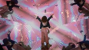 Pink Kaleidoscope illusion with woman standing in the middle at Twist Museum. 