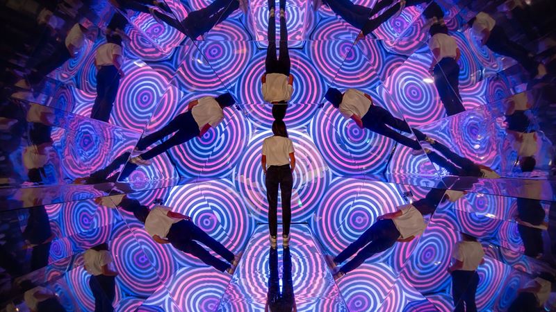 Twist Museum in Oxford Street. Image courtesy of Twist Museum. A person stands in an optical illusion exhibition at the twist museum in London.