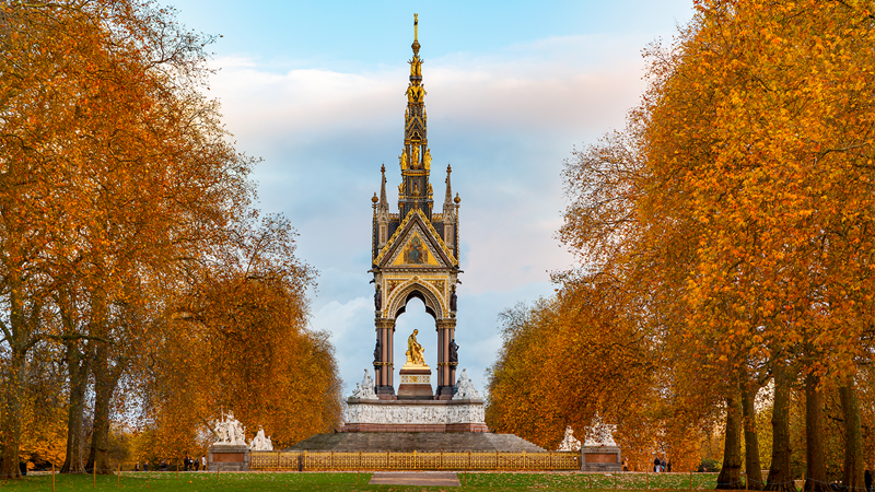 Enjoy the beautiful grounds of Kensington Gardens. Credit: Jon Reid. Image courtesy of Visit London. Albert Memorial at Kensington Gardens in London surrounded by trees with autumn foliage.