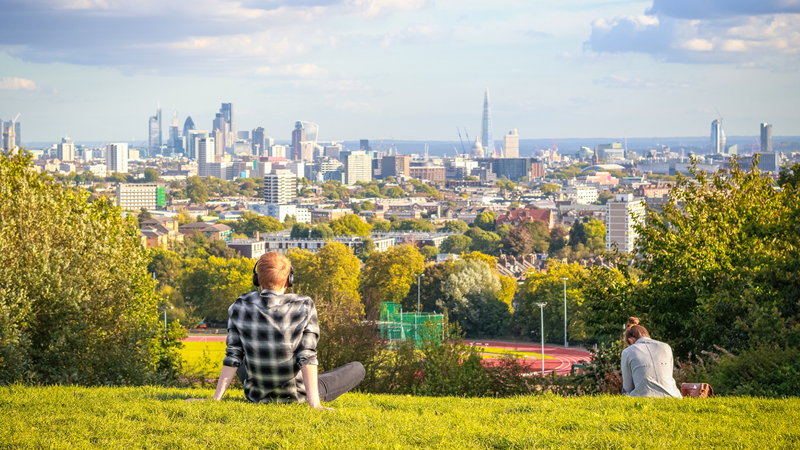 Marvel at London's iconic sights from the top of Parliament Hill on Hampstead Heath. Credit: Shutterstock. Image courtesy of Shutterstock. A young man admires the London skyline from Parliament Hill