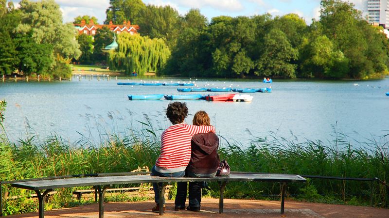 Spot the wildlife nesting on Regent's Park boating lake. Credit: Shutterstock. Image courtesy of Shutterstock. Two children sit on a bench, one with their arm around the other, and look out over a lake with small blue boats on it.
