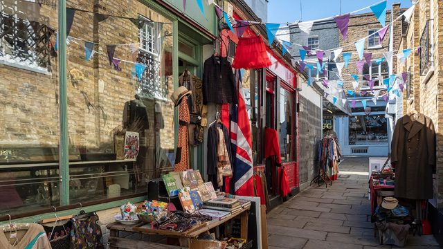 Clothes and vintage items hanging outside an antique shop in Camden Passage.