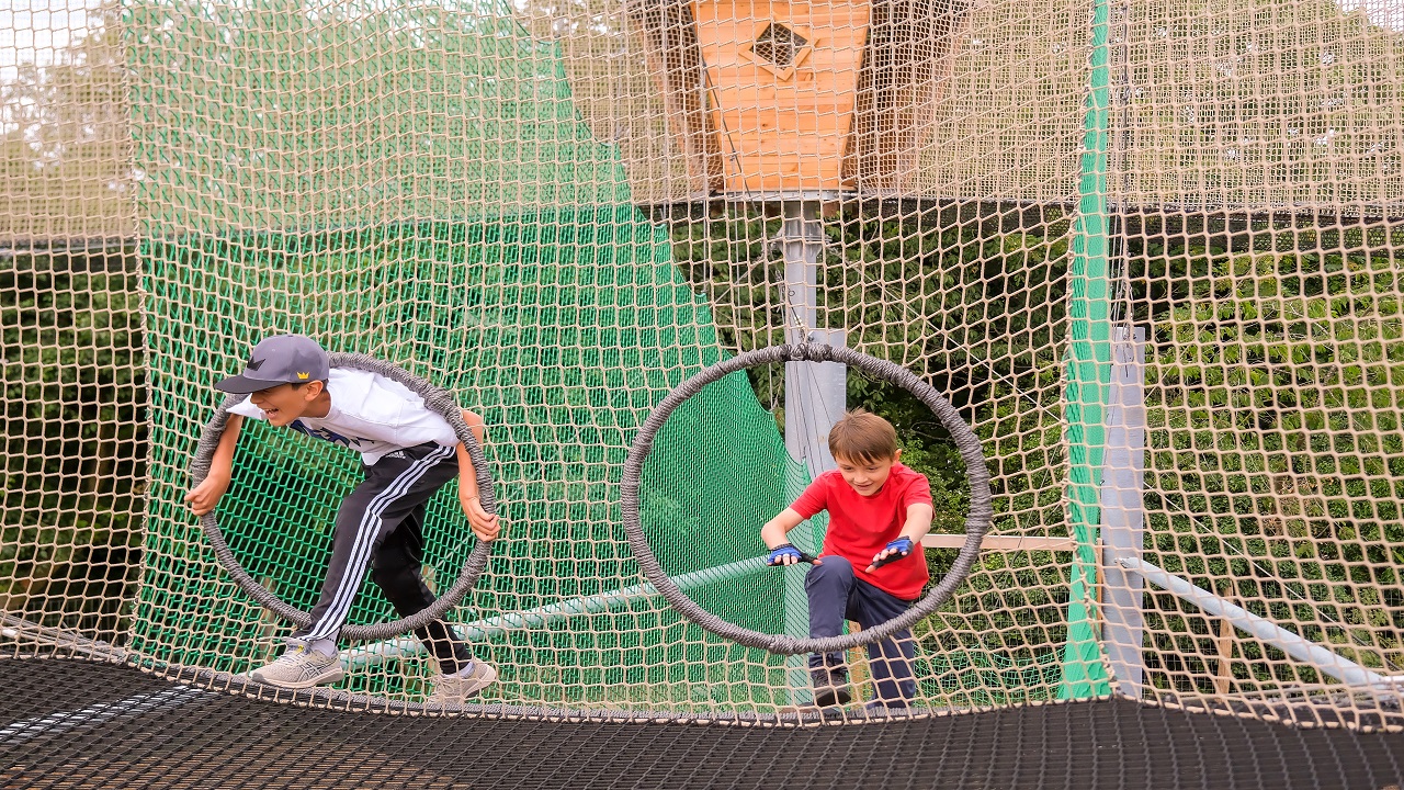 Fun activities for all ages at Gripped London including the Net Adventure Park. Image courtesy of Golden Tours. two young boys have fun climbing through a netted obstacle course