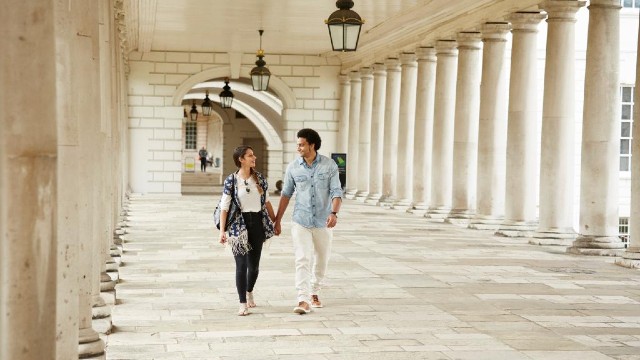 The colonnades of Queen's House, Greenwich. Image courtesy of the Royal Museums Greenwich. A couple walk in the colonnades of Queen's House in Greenwich.