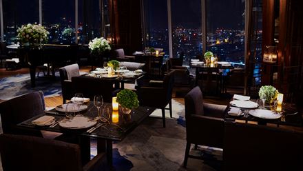 Chairs and tables set for dinner at night. Image courtesy of Shangri-La The Shard, London.