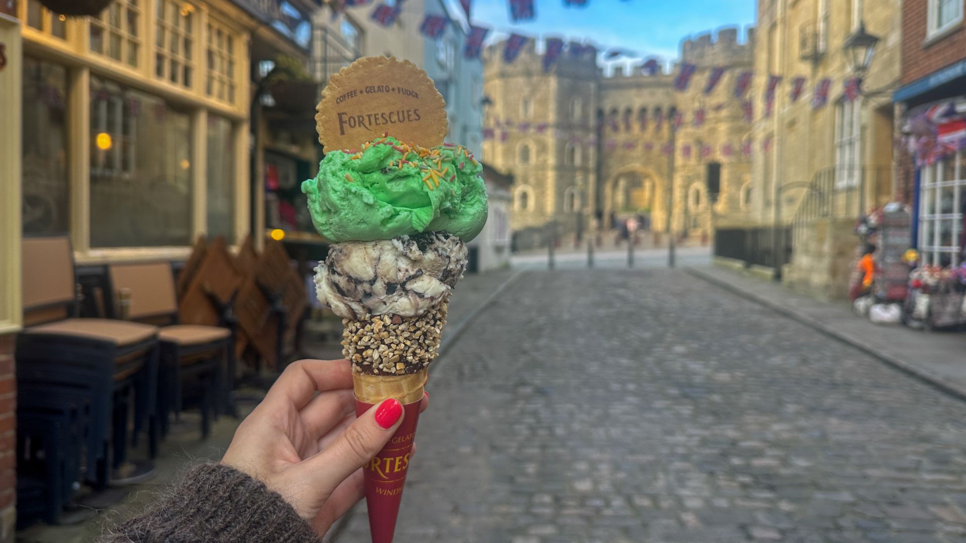 Sample delicious gelato from Fortescues in Windsor. © Visit London/Kirstine Spicer A hand holds an ice cream cone with a scoop of oreo and green mint choc chip.