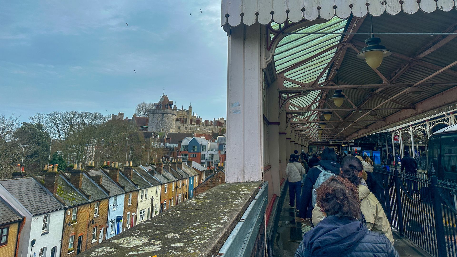 Spot the castle walls from the station platform upon your arrival. © Visit London/Kirstine Spicer People walk along the platform at windsor train station.