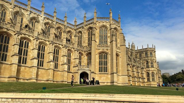 The exterior of gothic-style St George's Chapel at Windsor Castle on a clear day with blue skies.