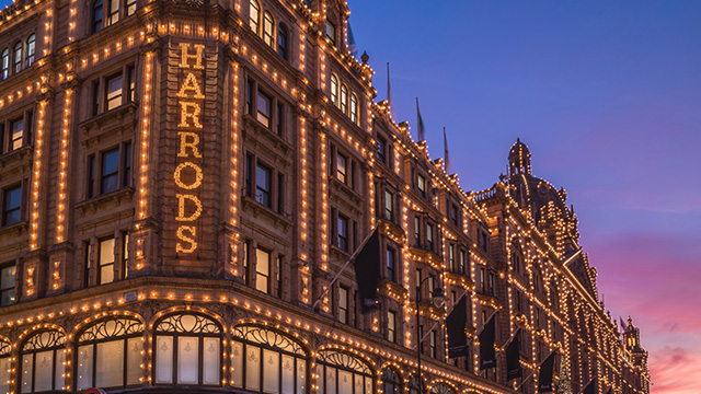 Harrods storefront lit up during sunset