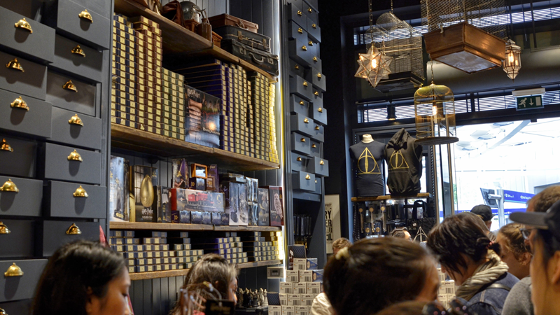 Step inside the whimsical world of Harry Potter at the shop of the same name in King's Cross. Credit: Shutterstock. Image courtesy of Shutterstock. People stood inside the Harry Potter shop in King's Cross with messy drawers reaching the ceilings and stacks of boxes and trinkets that look like they came from the film