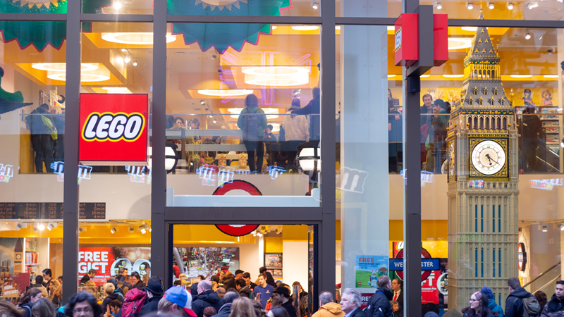 A view of the Lego store in Leicester Square from outside with crowds of people outside and a giant Big Ben display made entirely of Lego in the window