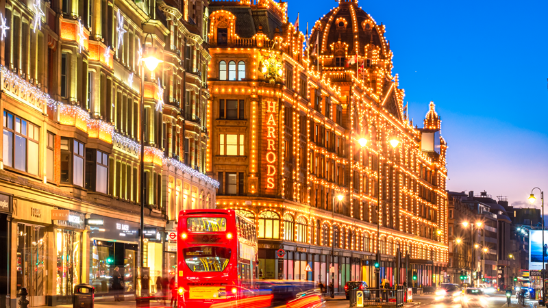Admire the exterior of Harrods which has become an iconic London landmark. Credit: Shutterstock. Image courtesy of Shutterstock. Warm twinkling lights cover the exterior of Harrods during Christmas during blue hour as light trails from cars and a red London bus sweep across the foreground