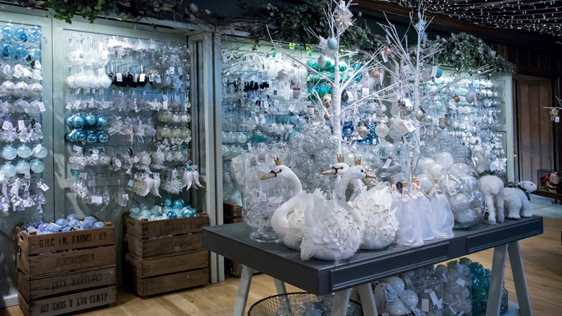 Find exclusive discounts at stores such as the iconic Liberty London. Credit: Shutterstock. Image courtesy of Shutterstock. White and blue-themed Christmas decorations at Liberty London including shelves of baubles, decorative trees and swans