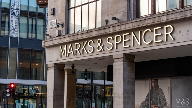 Visit Orchard House, the flagship Marks and Spencer store on Oxford Street which sells a wide range of popular British goods. Credit: Shutterstock. Image courtesy of Shutterstock. A close up photo of the Marks & Spencer logo on the art deco Orchard House building
