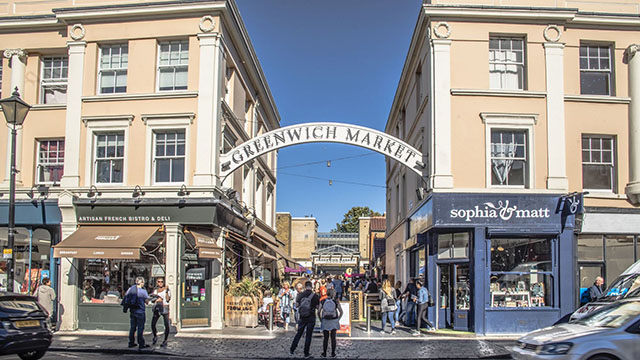 Browse stalls at Greenwich Market. Image courtesy of Ed Simmons/Greenwich Market. A couple stand in the street looking at the entrance to Greenwich Market.