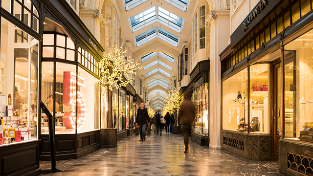 Shop in Burlington Arcade in Mayfair. Image courtesy of Ben Pipe/Visit London. Looking along Burlington Arcade, with little shops and Christmas decorations either side and people further along the arcade.