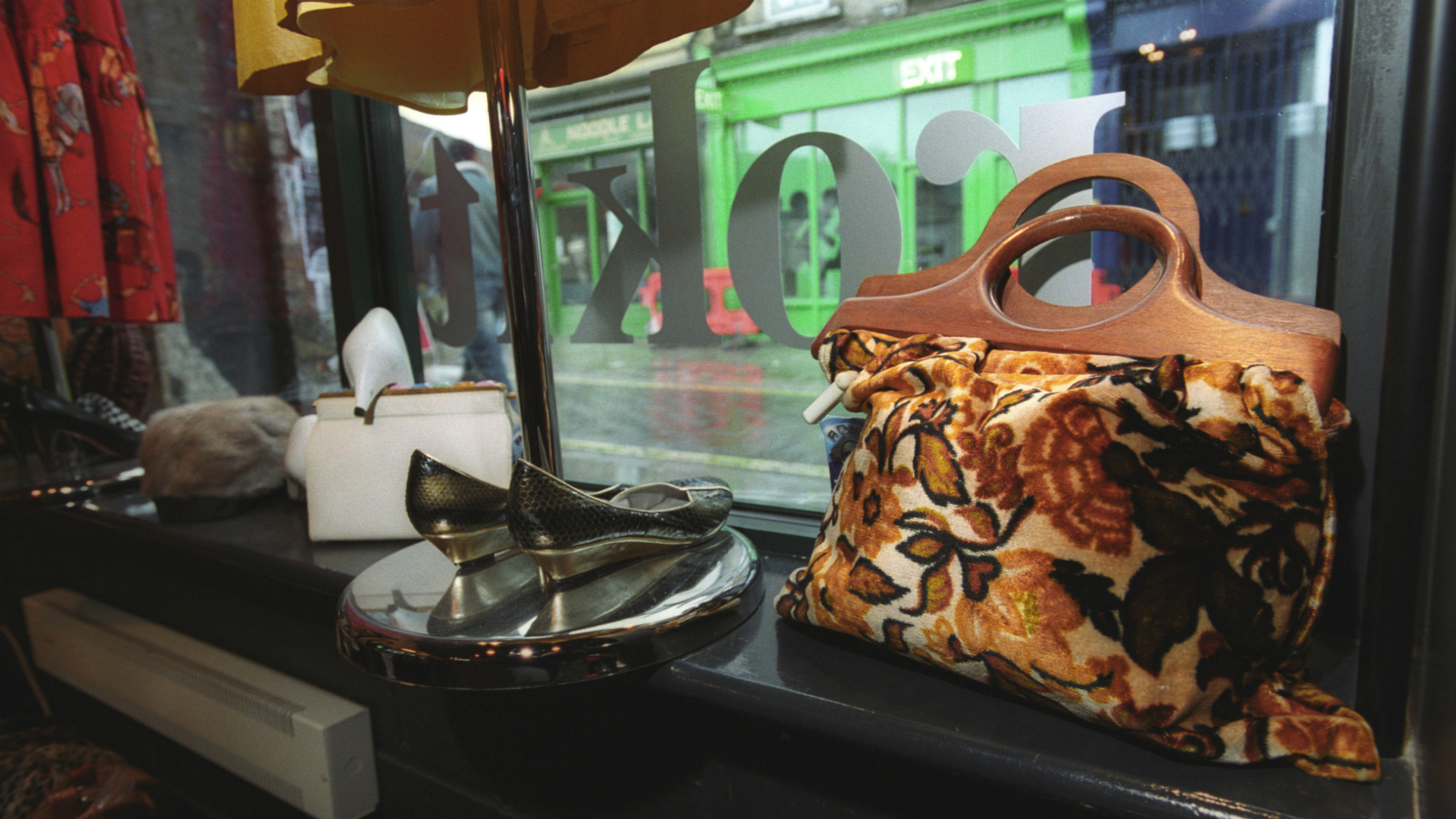 Shop for vintage fashion at Rokit. Image courtesy of Rokit. A vintage orange and brown retro bag and black shows in the window display at Rokit.