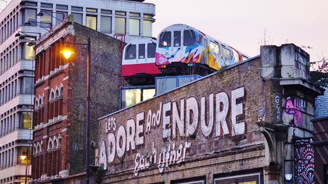 Street art and tube train offices in Shoreditch. Image courtesy of Shutterstock. Street art and tube train offices in Shoreditch.