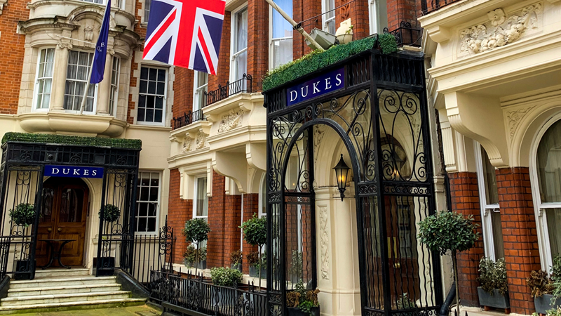 Head to the sophisticated Dukes in Soho where regular, Ian Fleming, is said to have been inspired. Credit: Shutterstock. Image courtesy of Shutterstock. A photo of the entrance to Dukes London from outside with a Union Jack flag hanging down and the name written across a black doorway