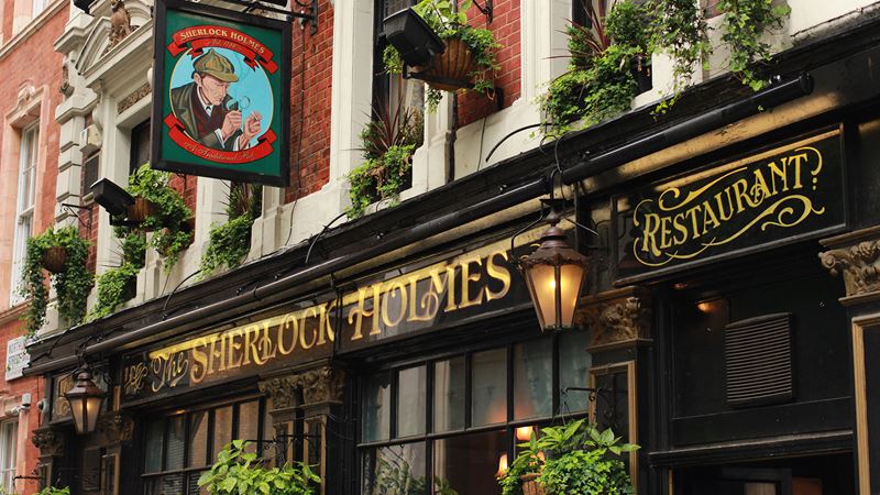 Enjoy a pint at The Sherlock Holmes pub in London. Credit: Shutterstock. Image courtesy of Shutterstock. The black and gold Sherlock Holmes pub facade, with pub sign displaying a drawing of the famous detective.
