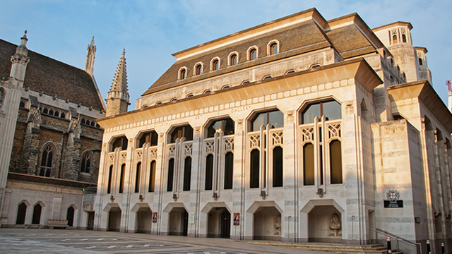 The Guildhall Art Gallery building in the sunshine against the blue sky.