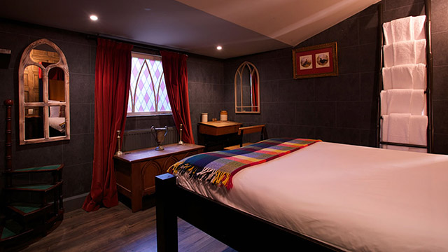 Wizard Chamber room at Georgian House Hotel. Credit: Georgian House Hotel. Image courtesy of Georgian House Hotel. A Harry Potter-themed room at Georgian House Hotel, complete with red-velvet curtains, white sheets and dark wooden floor.