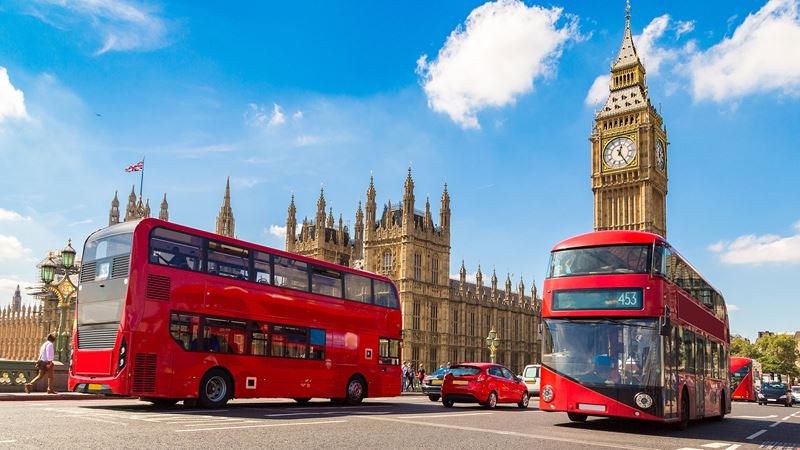 Take the double-decker bus and stop off at Westminster to admire Big Ben and visit the Houses of Parliament. Credit: Shutterstock. Image courtesy of Shutterstock. Two red double-decker buses go past Big Ben and the Houses of Parliament on a sunny day.