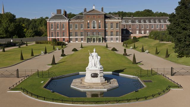 Queen Victoria statue in Kensington Gardens with Kensington Palace in the background © Historic Royal Palaces/Robin Forster. Image courtesy of Historic Royal Palaces/Robin Forster. Queen Victoria statue in Kensington Gardens with Kensington Palace in the background on a sunny day.