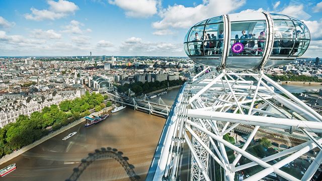 A view from the top of the London Eye, taken on a bright day from one capsule, with another capsule in the foeground and views of the river Thames and London skyline in the background.