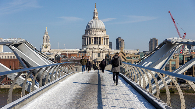 Millennium Bridge and St Paul's Cathedral in the snow. Image courtesy of Shutterstock. A view along Millennium Bridge towards St Paul's Cathedral, with snow and people walking on the bridge.