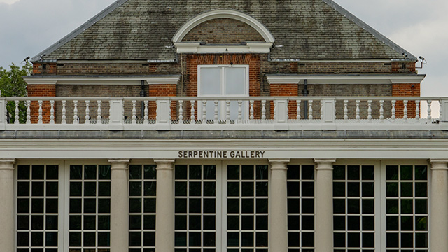 A tall building with a balcony and high windows.