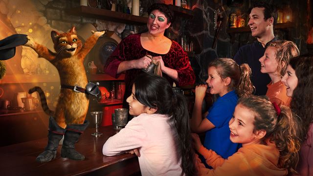 The Puss in Boots is on a table in front of children in Shrek's Adventure! London.