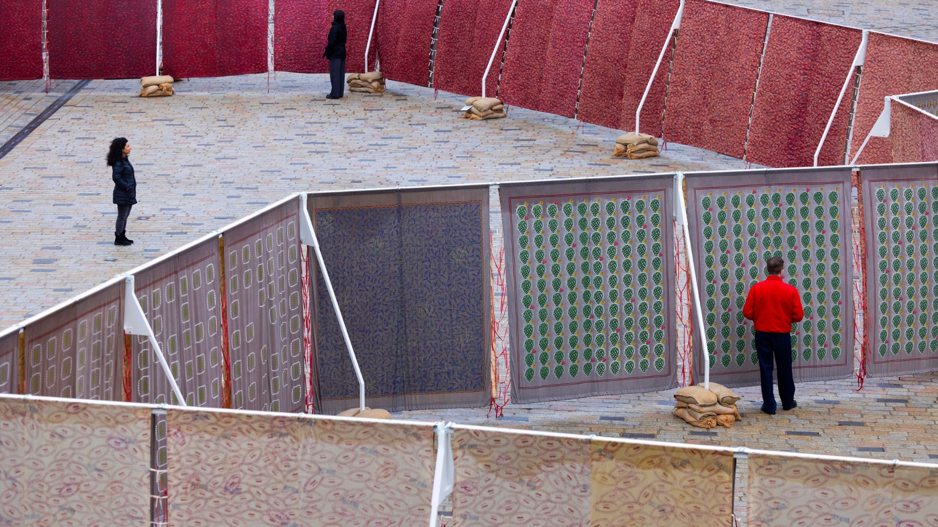 Salt Cosmologies courtyard installation by HylozoicDesires at Somerset House. Image courtesy of Somerset House. People standing either side of a fabric installation in the courtyard of Somerset House.
