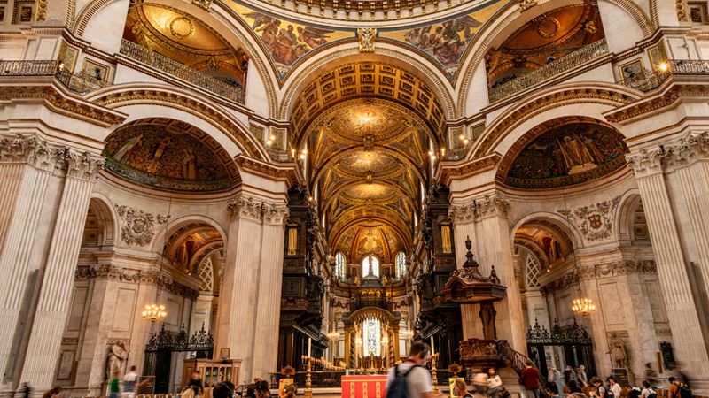 Enter St Paul's Cathedral and marvel at the architecture and memorials that bear witness to the great leaders who have walked within its walls. Credit: London & Partners/Michael Barrow. Image courtesy of visitlondon.com. Visitors roam the walls of St Paul Cathedrals admiring its high ceilings.