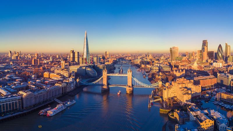 Wide panorama over London and its many iconic monuments by a sunny day, including Tower Brisge abd The Shard.