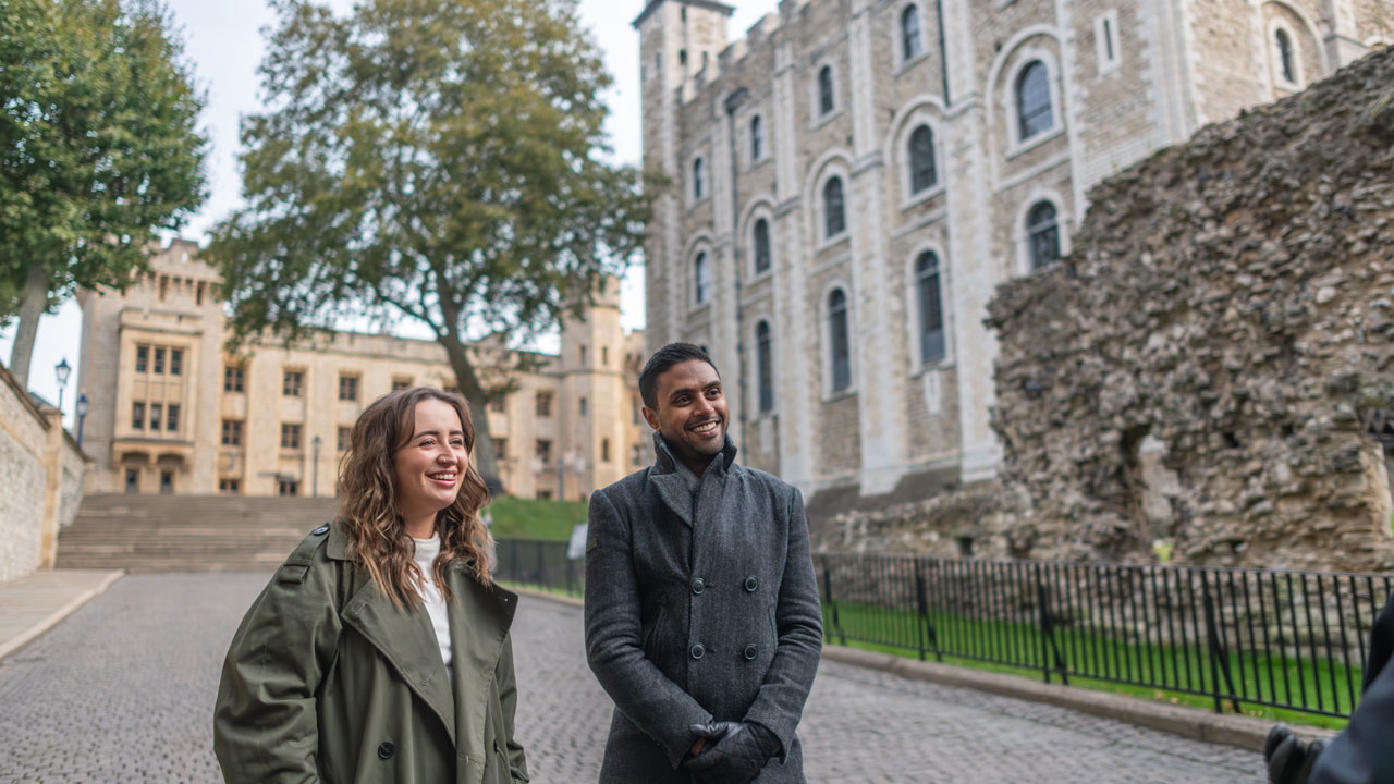 Learn about 1,000 years of history at the Tower of London and hear about the days when it was known as the Bloody Tower. © London & Partners/Michael Barrow A man and a woman are visiting the Tower of London and listing to their guide.