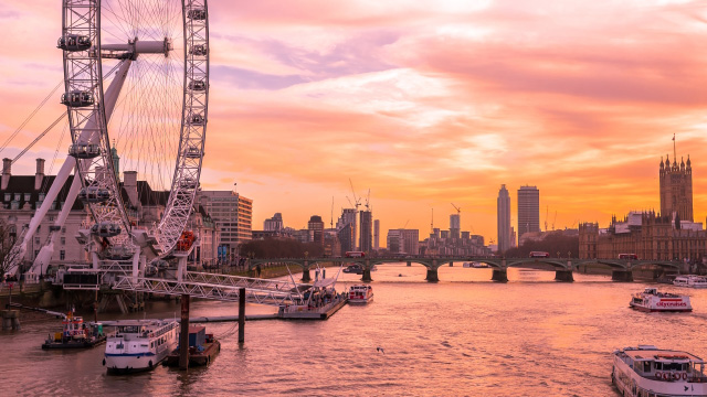 The London Eye at sunset facing the river Thames and the Houses of Parliament
