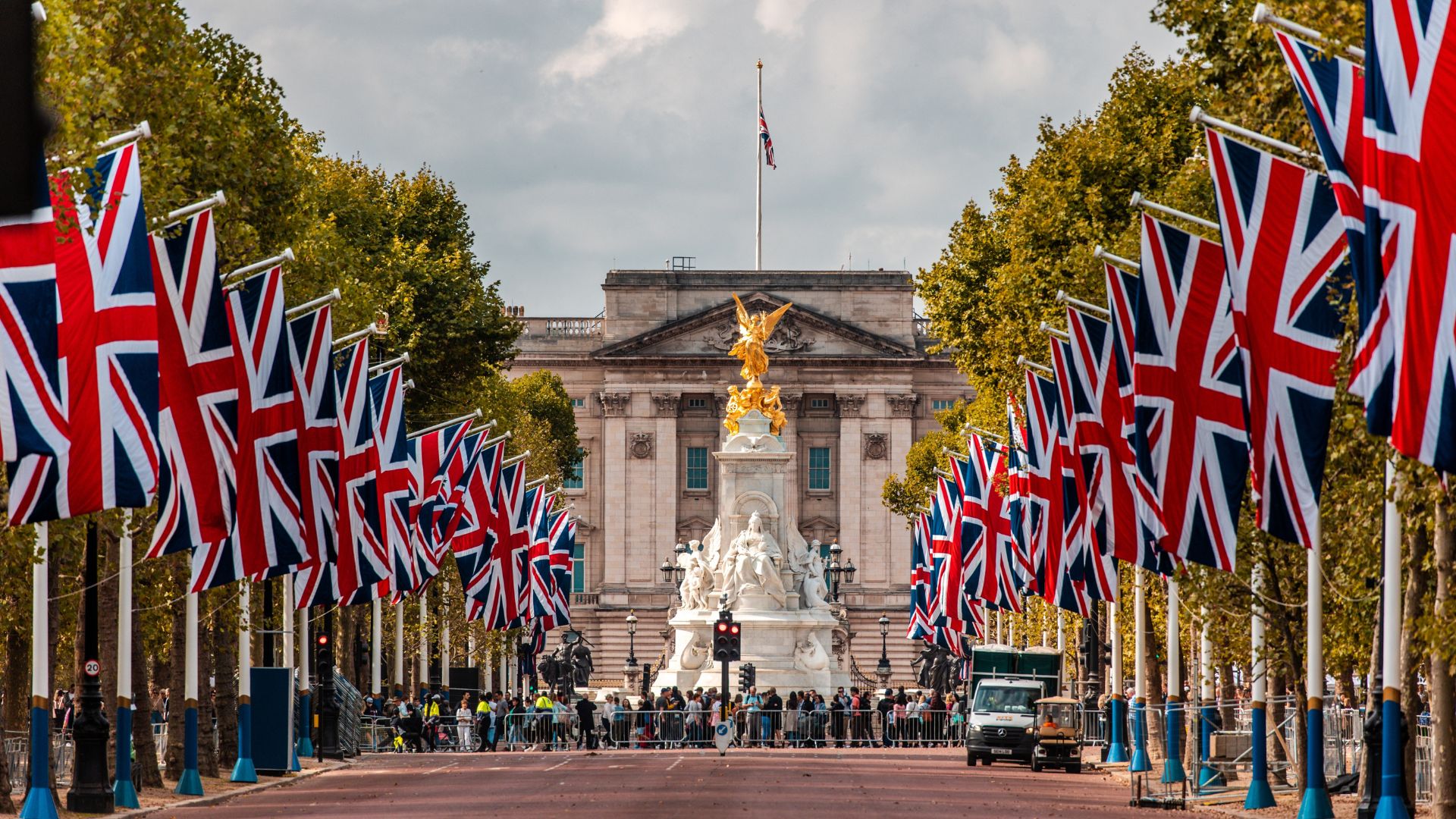 Buckingham Palace pictured from The Mall. Image courtesy of Shutterstock. Union jack flags lining The Mall with Buckingham Palace in the background.