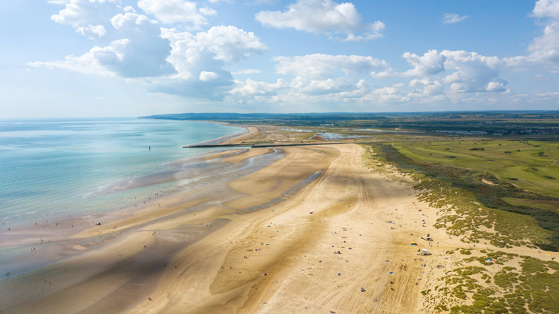 Camber Sands, East Sussex. Photo by Chris Mitchell on Unsplash. Aerial view of Camber Sands beach on a clear day.